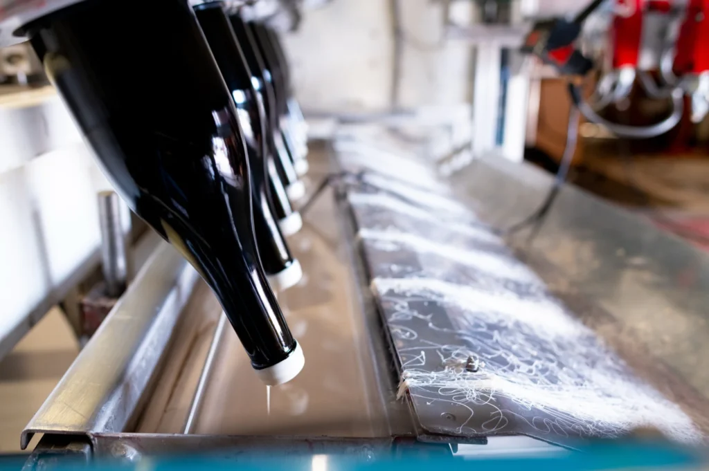 Cycle d'égouttage du cirage : bouteilles à l'envers et coulures de cire blanche